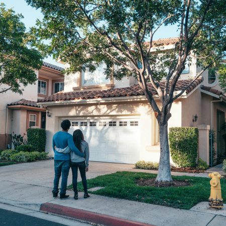Couple standing outside and looking at their house